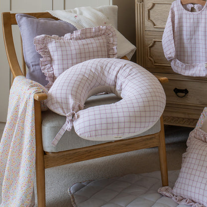 Round pillow with grid pattern on a wooden chair in a home setting