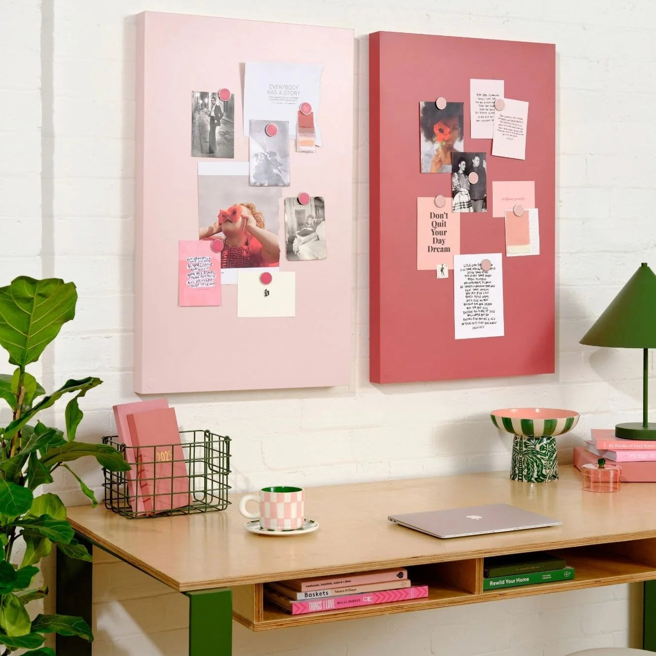 Desk with pink and red magnetic boards, plants, and a lamp in a home office setting.