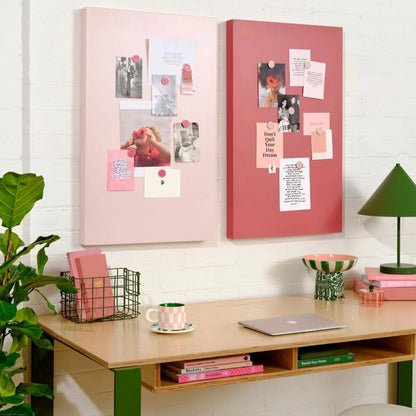 Home office setup with pink and red bulletin boards, desk, and decor items.