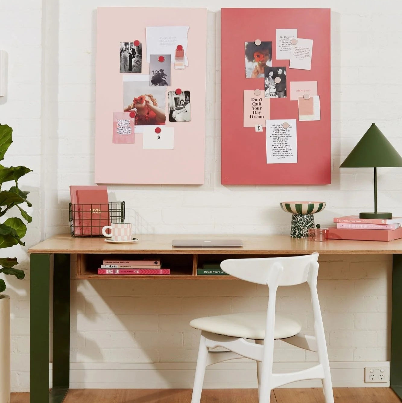 Home office with a desk, chair, and decorative elements on a white wall.