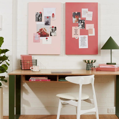 Home office with a desk, chair, and decorative elements on a white wall.