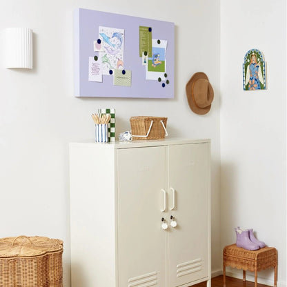 White cabinet with decorative items on a wooden floor in a room.