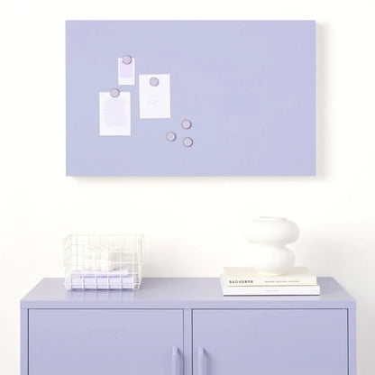 Light purple wall with a magnetic board and a cabinet below on a white background