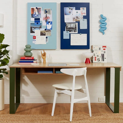 Home office setup with a desk, chair, and decorative elements on a white wall.