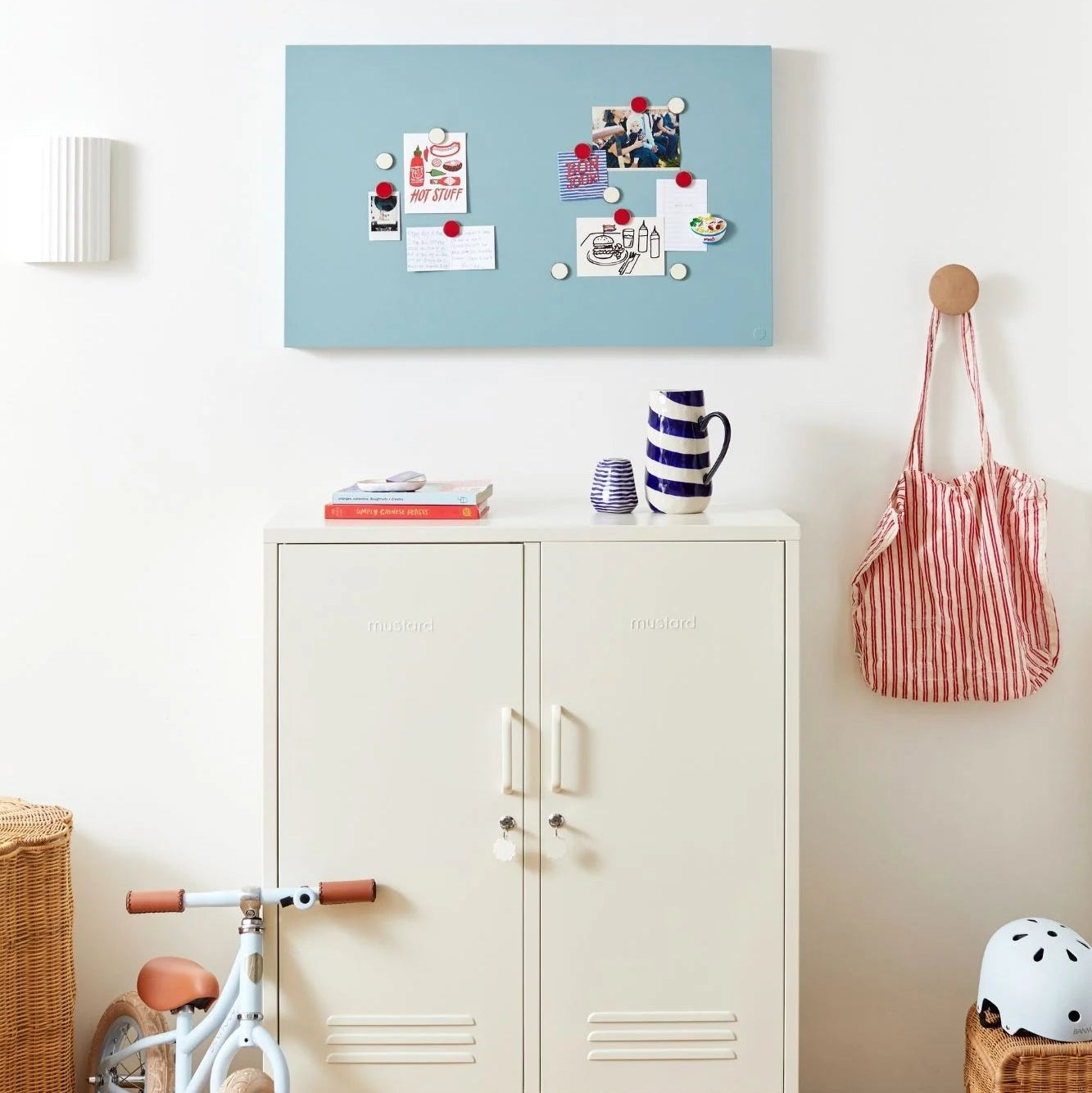 Children's room with a white cabinet, bike, and colorful decor.