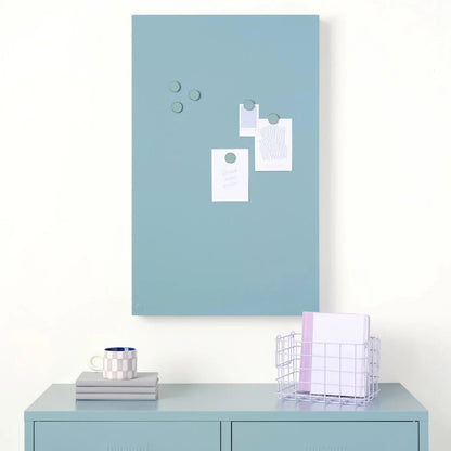 Light blue magnetic board on a white wall above a light blue locker.