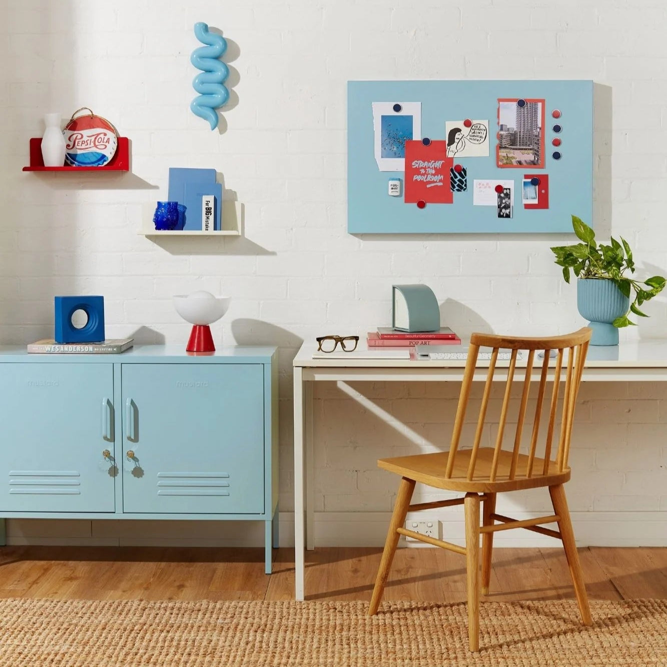 Home office with a desk, chair, and shelves with decorative items.