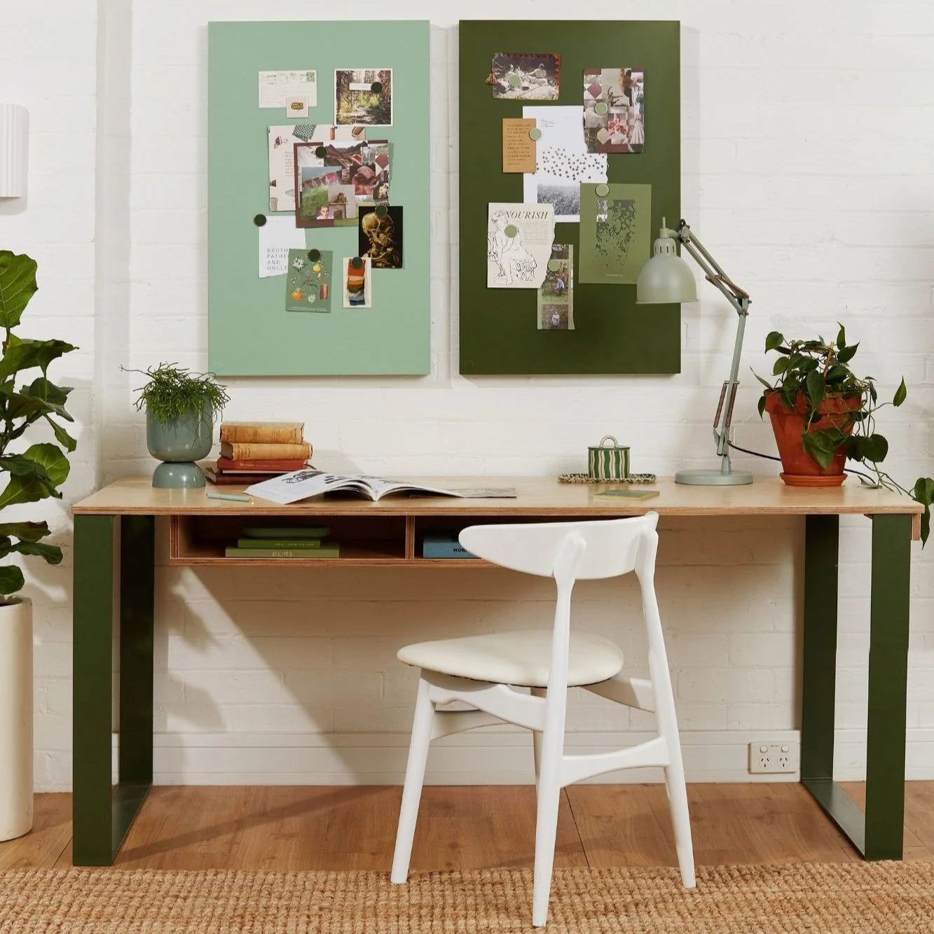 Home office with a wooden desk, white chair, and decorative elements on a white wall.