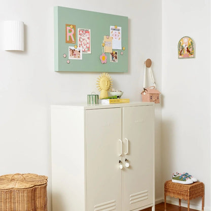 White cabinet with decorative items on a wooden floor in a room.