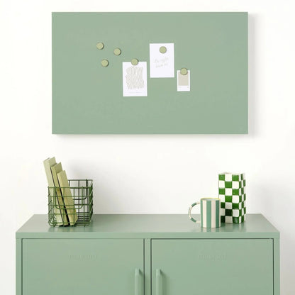 Green bulletin board with decorative items above a green locker.