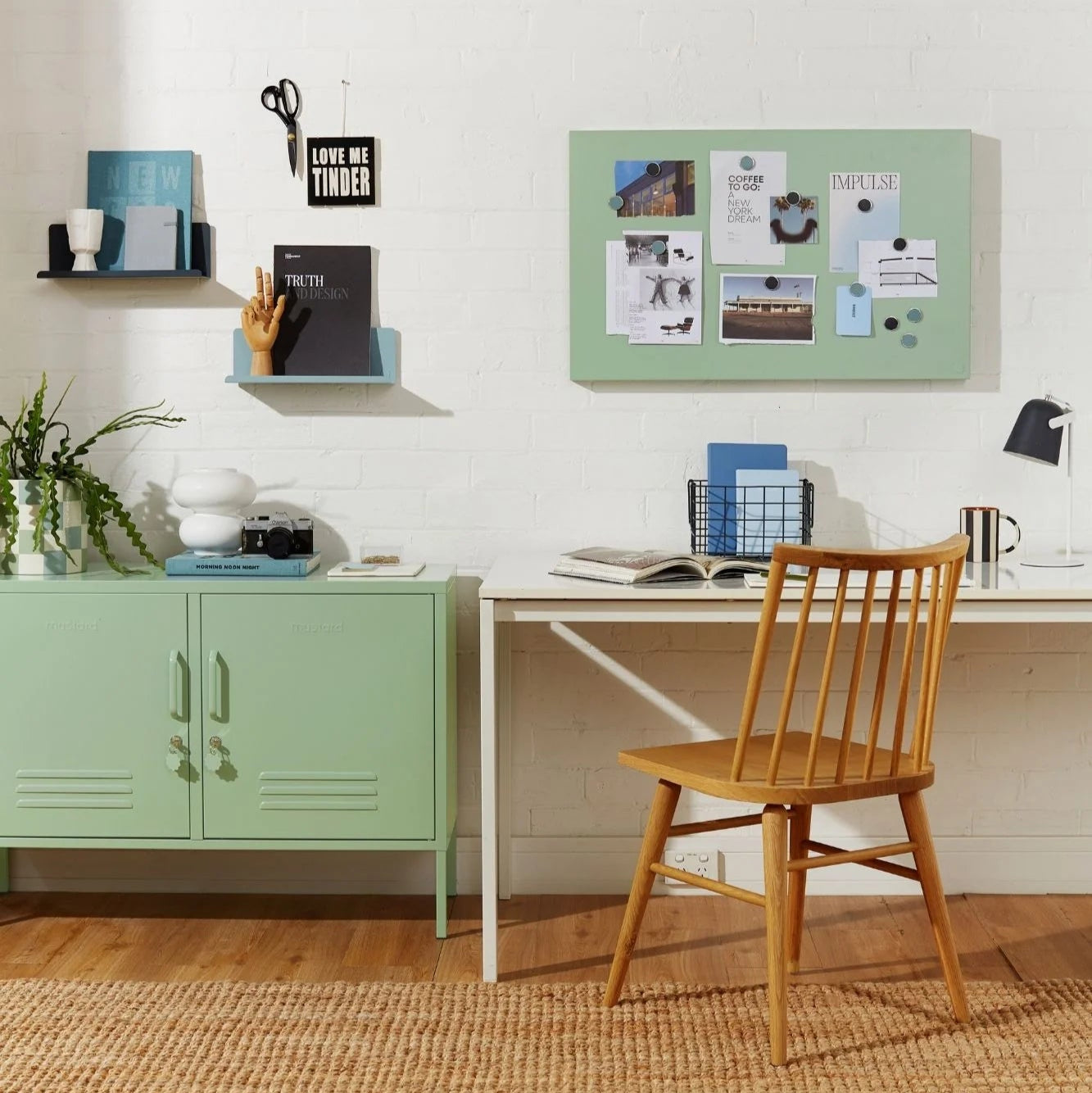 Home office with a wooden chair, desk, and green cabinets.