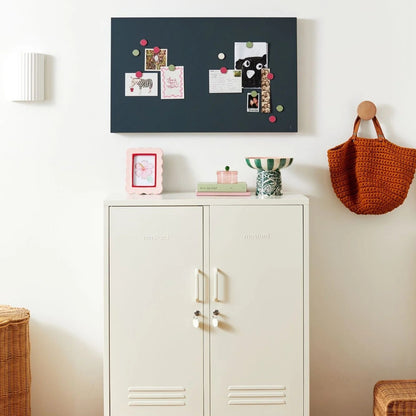 White cabinet with decorative items on a white wall