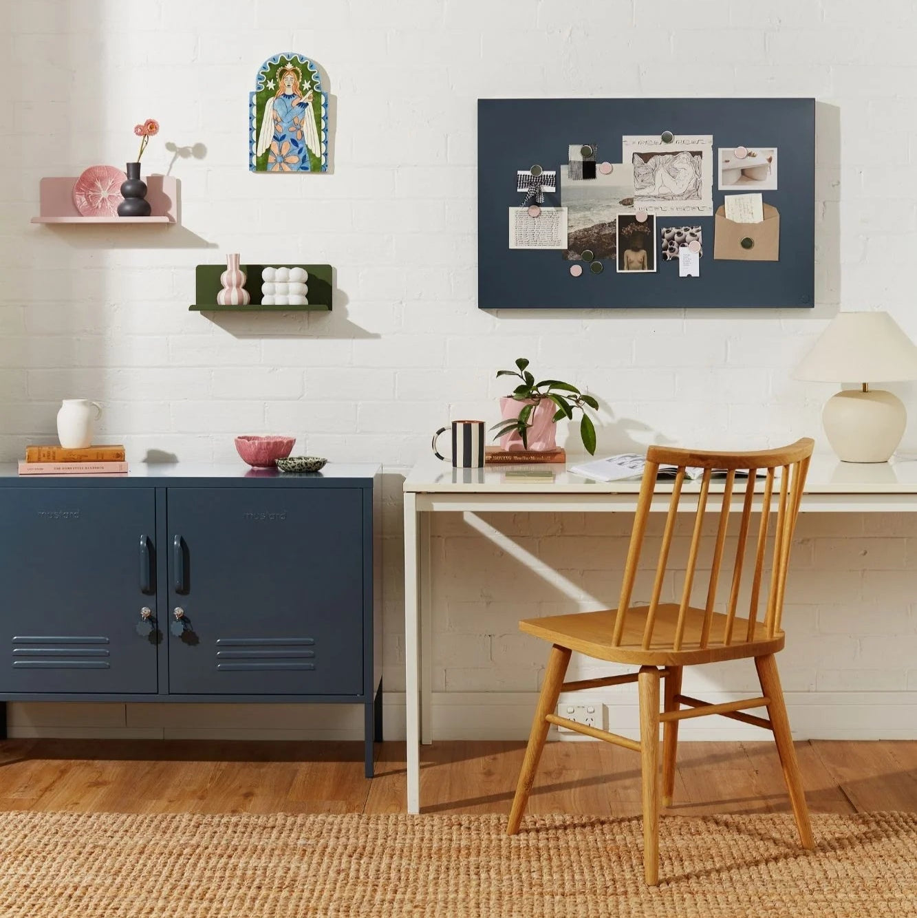 Home office with a desk, chair, and shelves against a white wall.