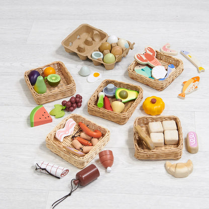 Set of toy food items and baskets on a light wooden surface
