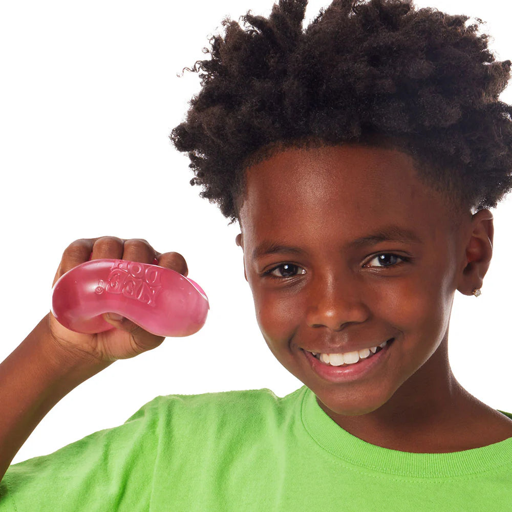 Child holding a pink stress ball against a white background