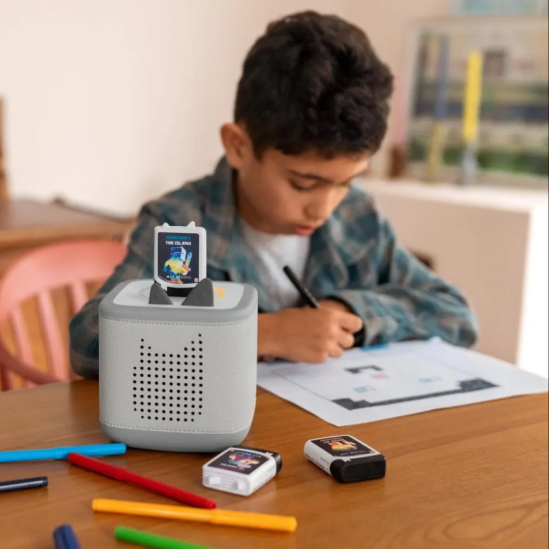 Child using a educational device with colorful markers on a table