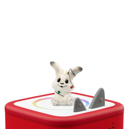 White rabbit toy with gray ears on a red and white platform with shark fin design against a white background