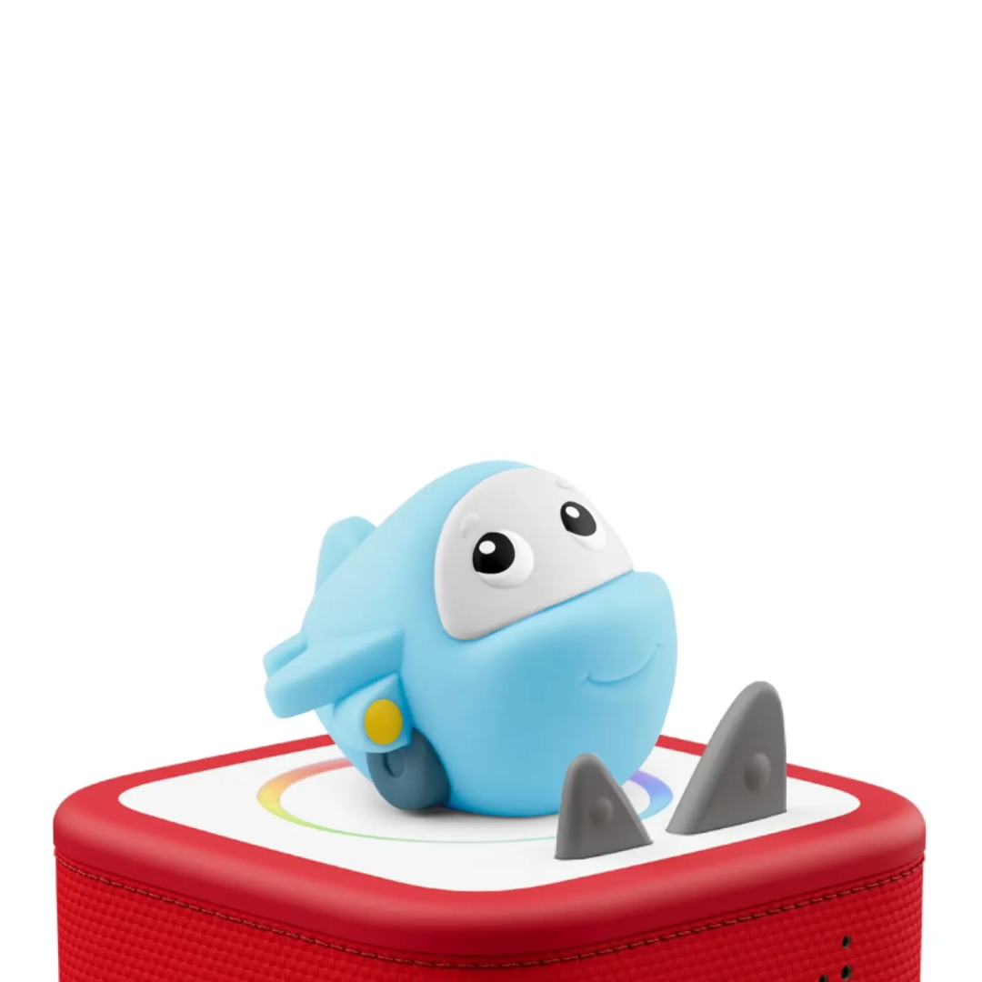 Blue toy shark on a red base with a white background