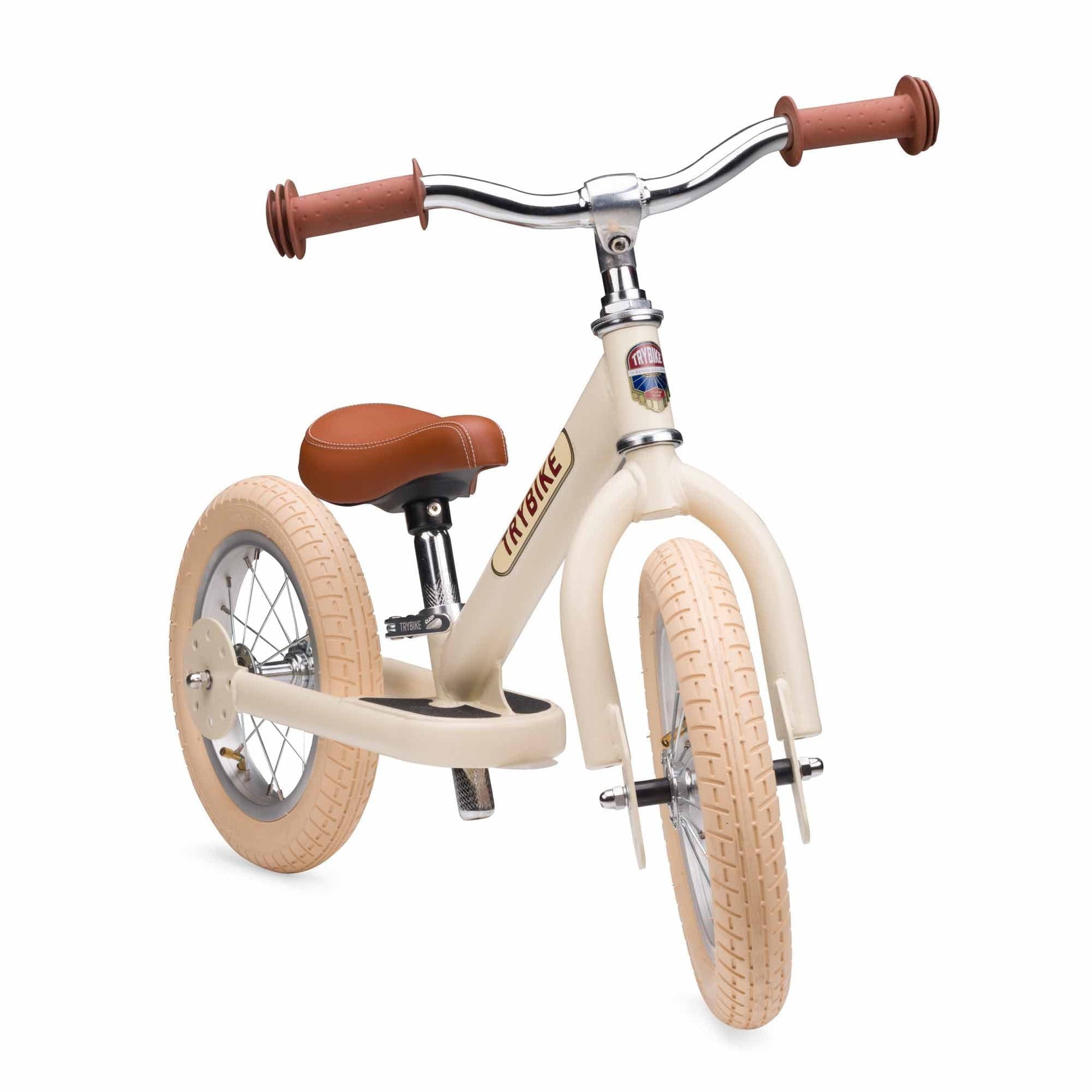 Beige balance bike with brown handlebars and seat on a white background