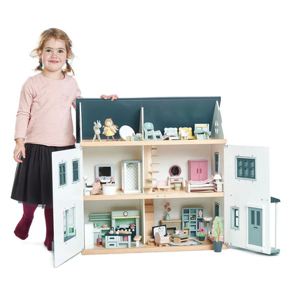 Child with a large dollhouse and its interior on a white background