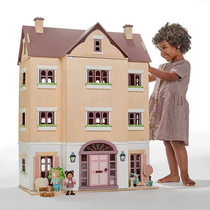 Child playing with a dollhouse and dolls on a white background
