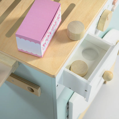 Wooden toy kitchen set with pink box on a light blue surface