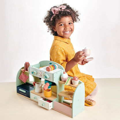 Child playing with a toy kitchen set on a white background