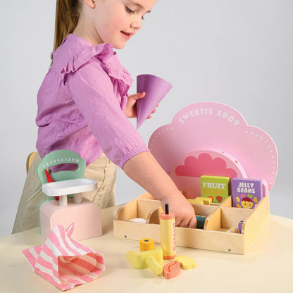 Child playing with a toy set on a table against a plain background