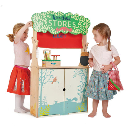 Children playing with a toy store set against a white background