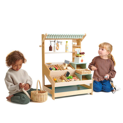 Children playing with a wooden toy kitchen set on a white background