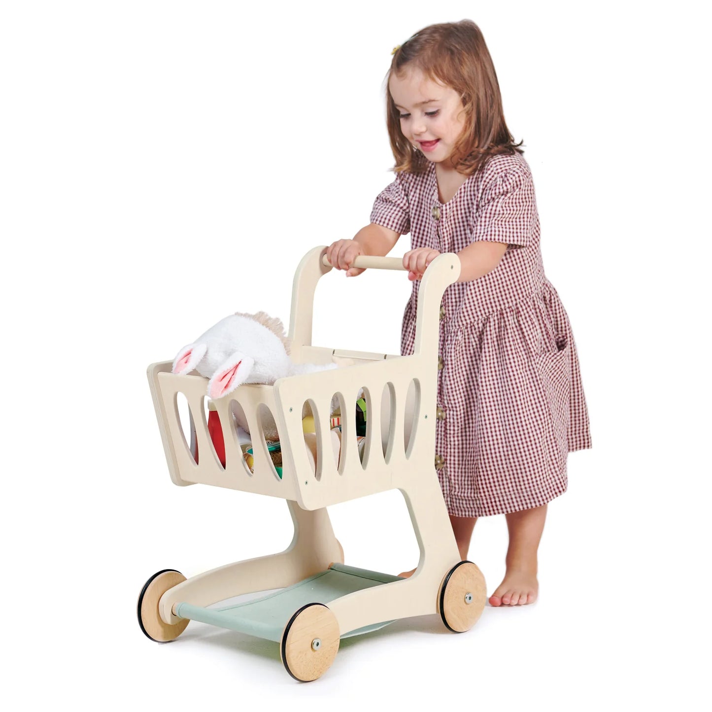 Child playing with a toy shopping cart on a white background