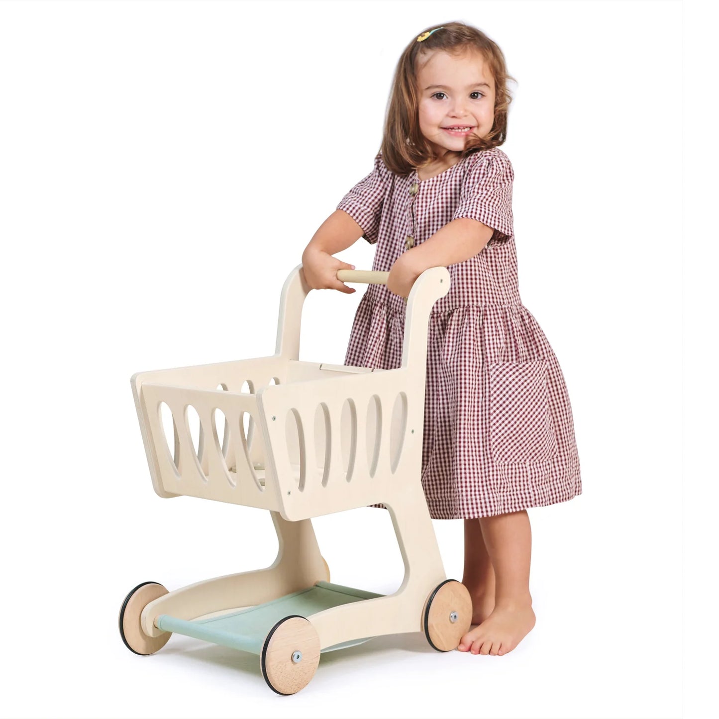 Child playing with a toy shopping cart on a white background
