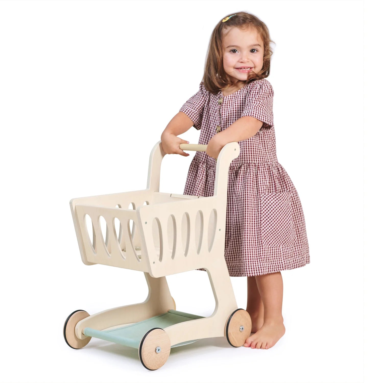 Child playing with a toy shopping cart on a white background