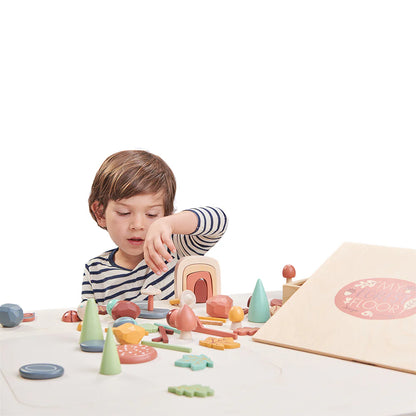 Child playing with colorful wooden toys on a white surface