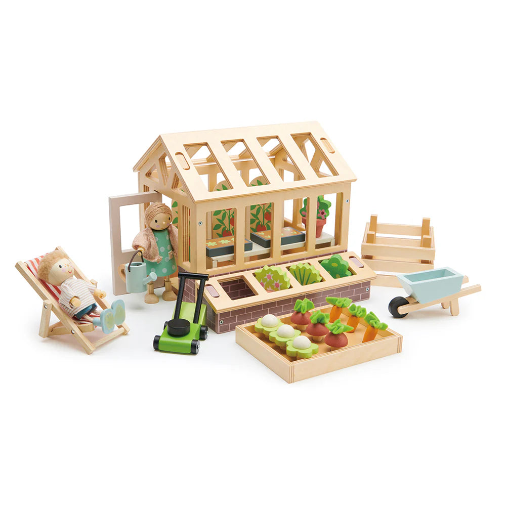 Wooden toy garden set with a greenhouse, tools, and vegetables on a white background