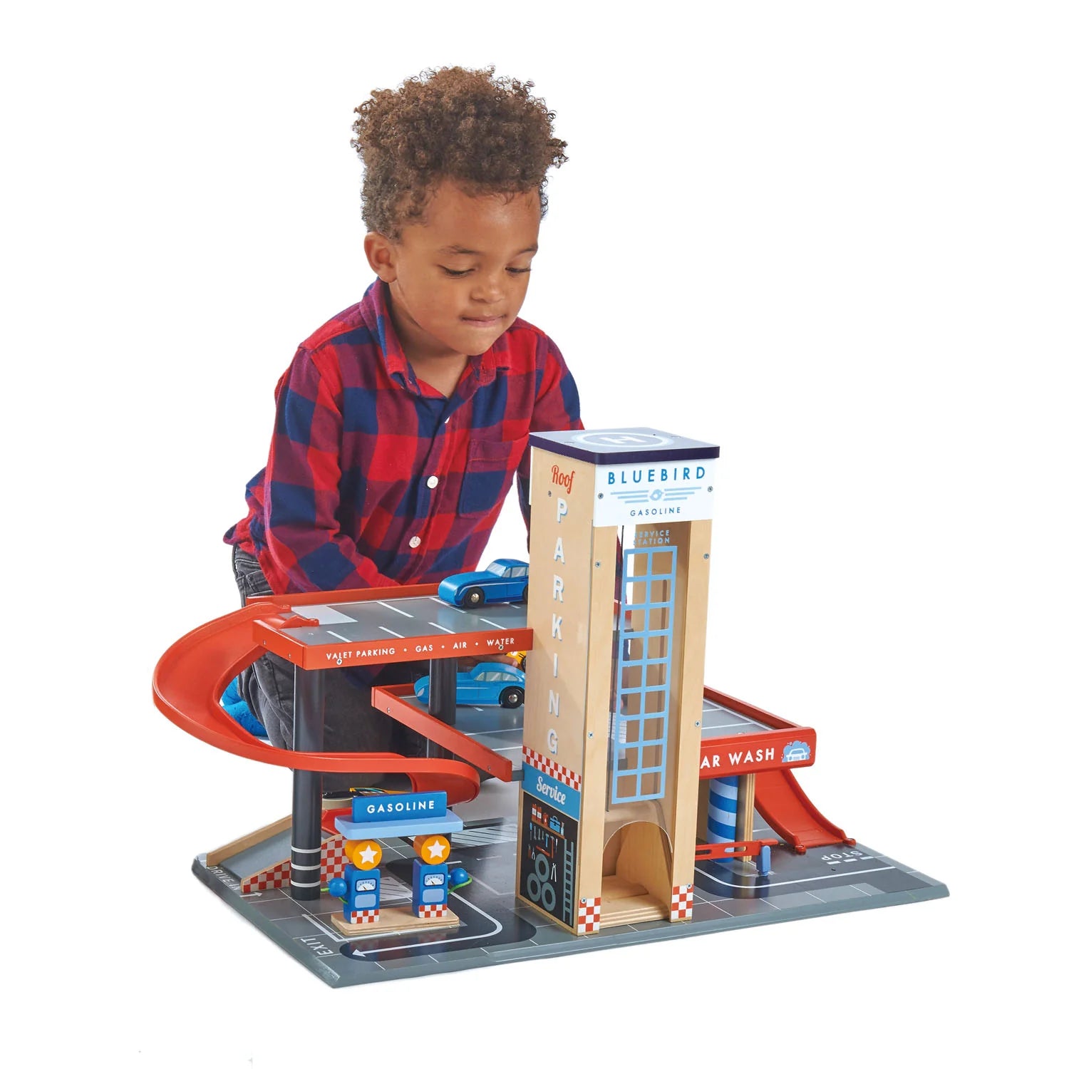 Child playing with a toy car wash set on a white background