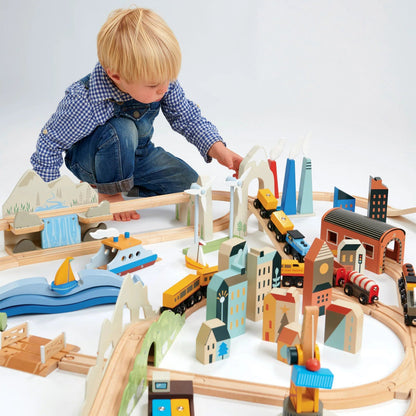 Child playing with a wooden train set on a white background