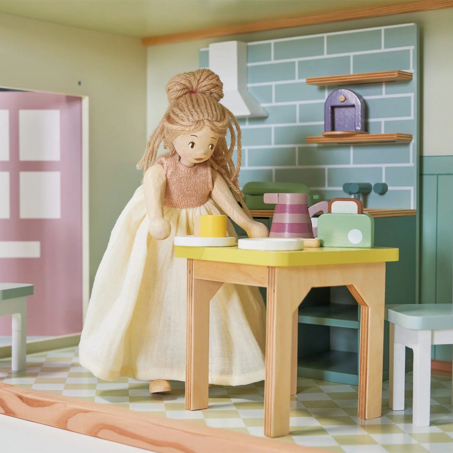 Doll in a kitchen setting with a table and chairs