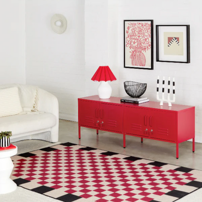 Modern living room with a red sideboard, white sofa, and geometric rug.