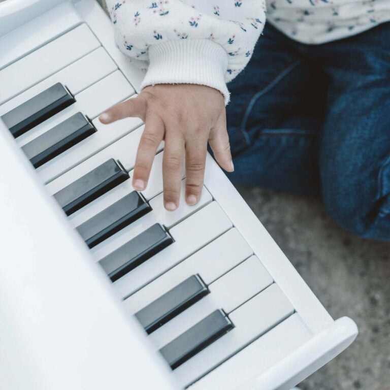 Child's hand on a small keyboard with a blurred background
