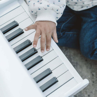 Child's hand on a small keyboard with a blurred background