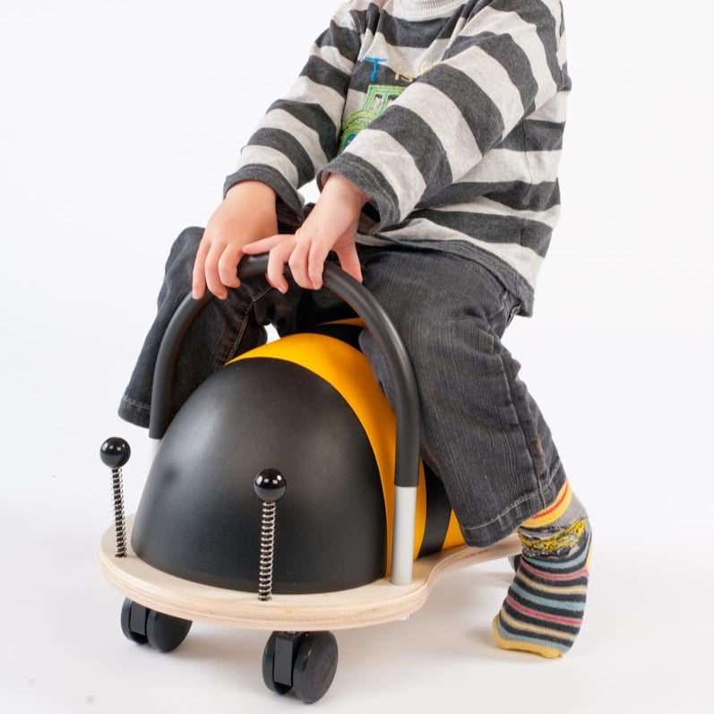Child sitting on a toy vehicle with a white background