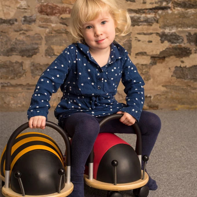 Child sat on a ladybug ride on toy