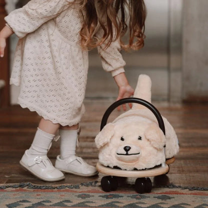 Child stood next to plush dog ride on toy