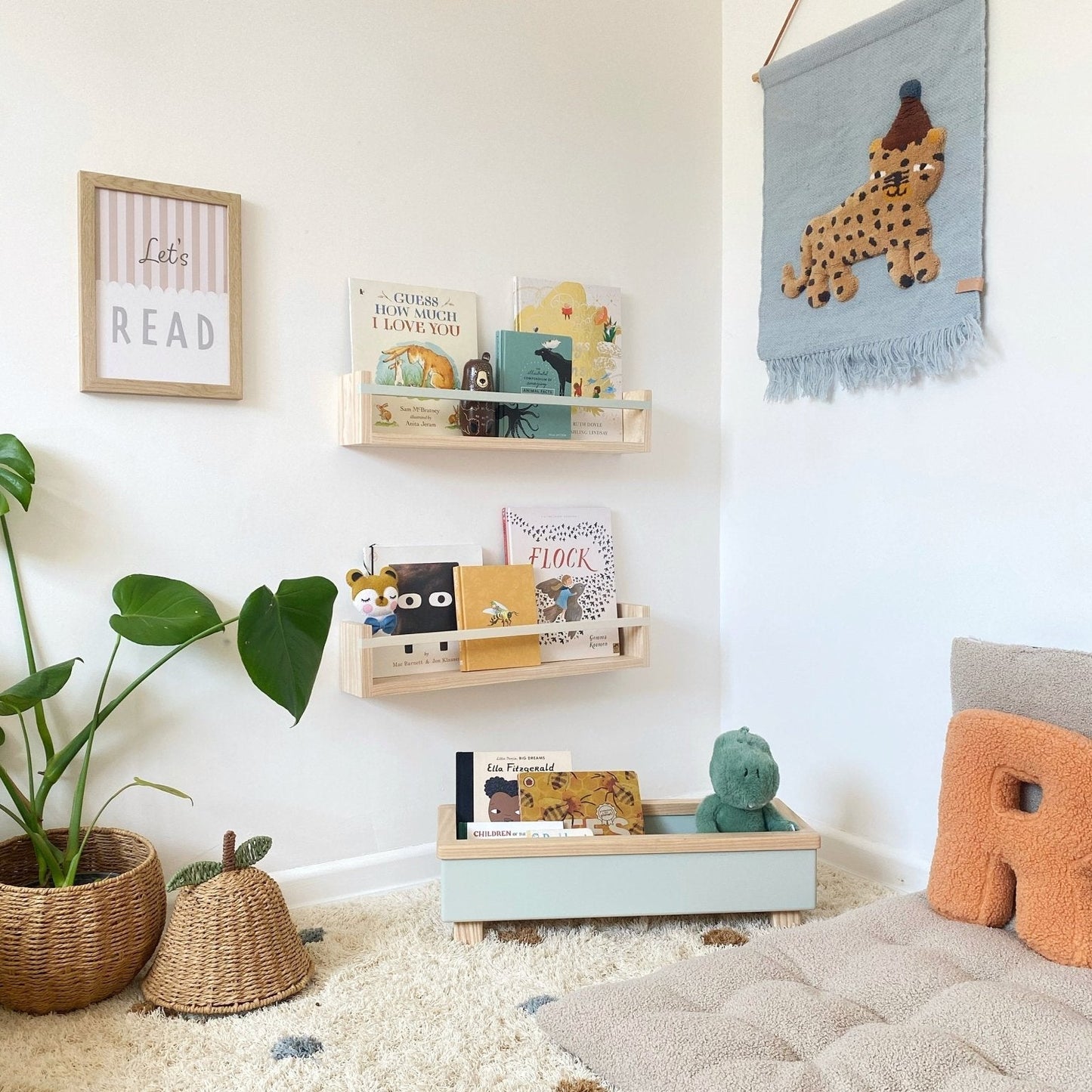 Children's room with shelves, books, and decorative items on a white wall.