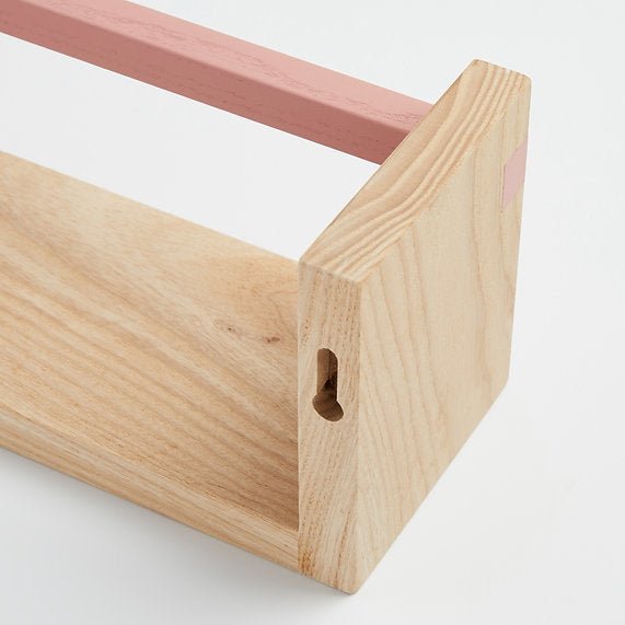 Close-up of a wooden shelf corner with a pink support rod on a white background