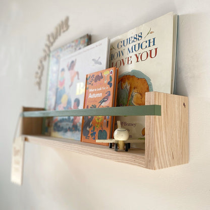 Wooden shelf with children's books on a white wall
