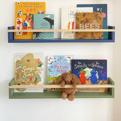 Children's books on wooden shelves against a white wall