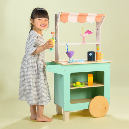 Child playing with a toy kitchen set on a light green background