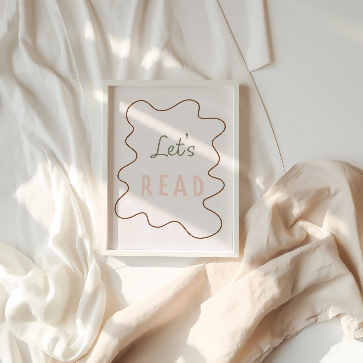 Framed artwork with 'Let's Read' text on a soft fabric background